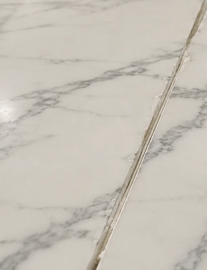 Discoloured, separating seam on a marble countertop before repair in Toronto